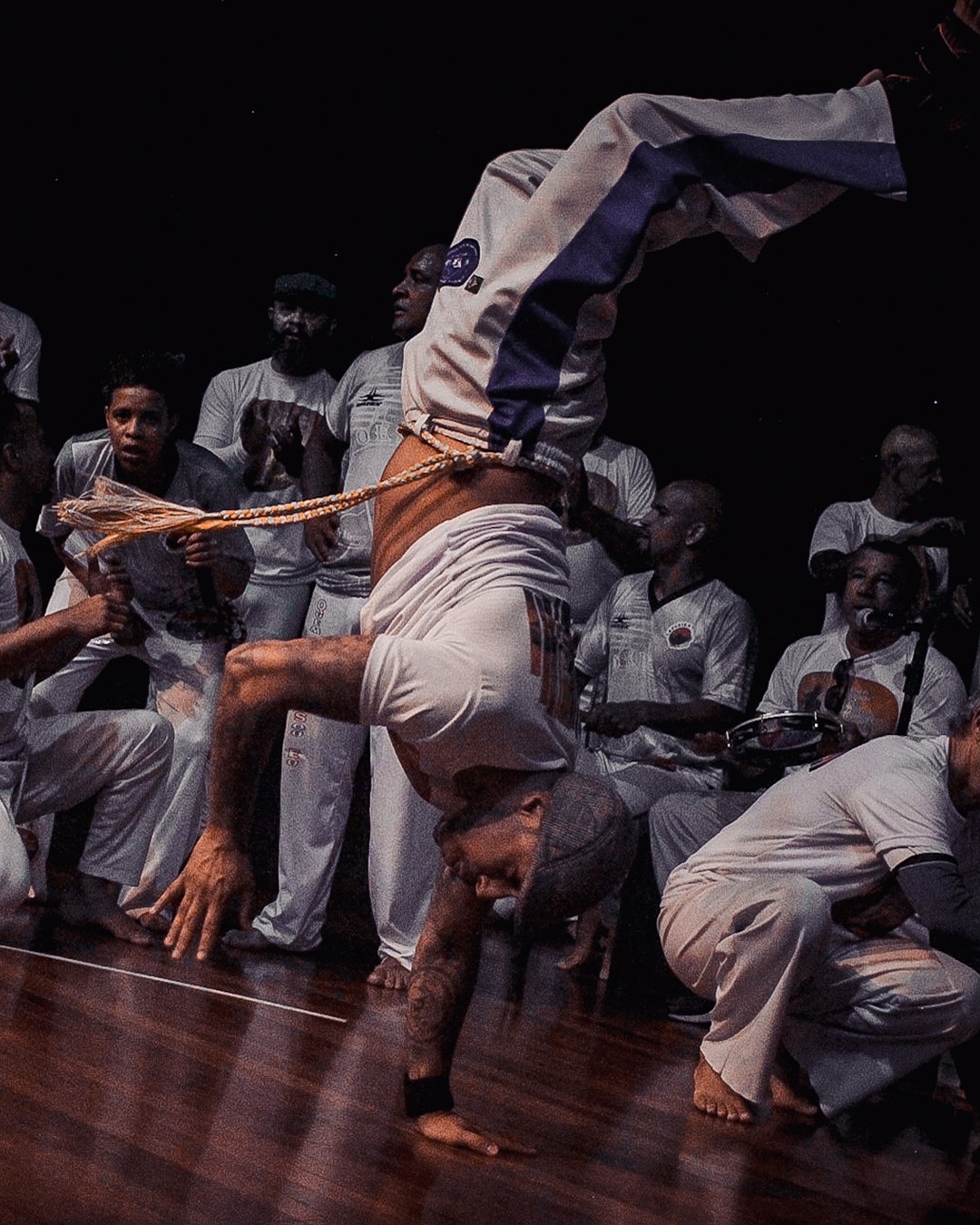 Capoeirista executando movimento no palco