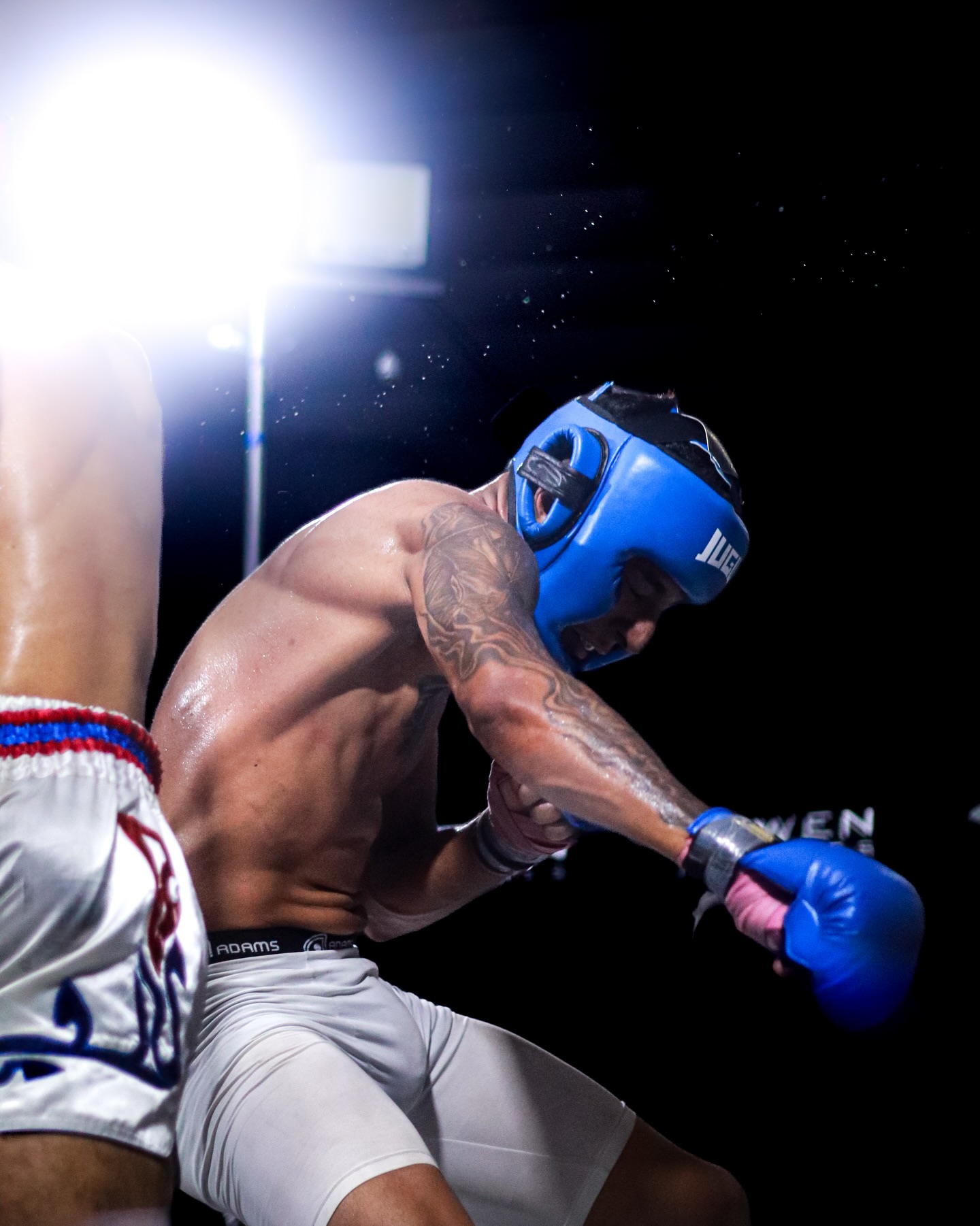 Lutador de MMA recebendo golpe no combate
